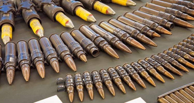 Filas de grandes cartuchos de munición expuestos en una exhibición de museo militar.