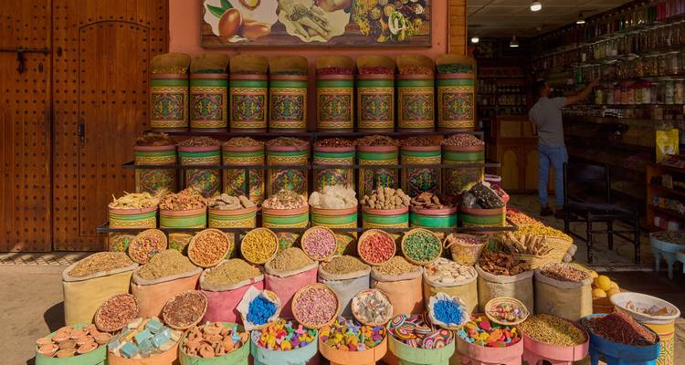 Colorful barrels of spices, herbs and sweets stacked invitingly outside a Moroccan souk shop.