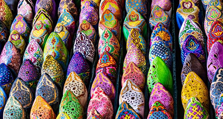 Rows of brightly colored embroidered Moroccan babouche slippers displayed in tight formation.
