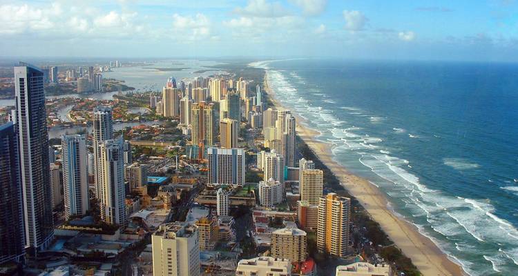 Aerial view of Gold Coast skyline running parallel to long sandy beach and ocean waves