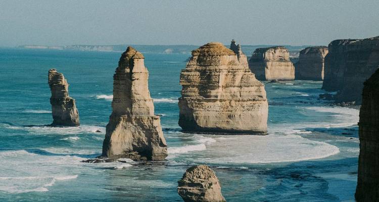 Limestone sea stacks of the Twelve Apostles rising from turquoise water along rugged coast