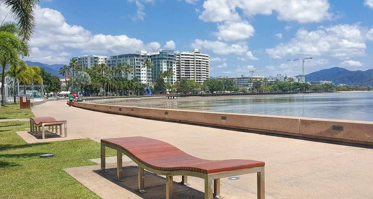 Cairns esplanade waterfront promenade with modern hotels, palm trees and calm lagoon