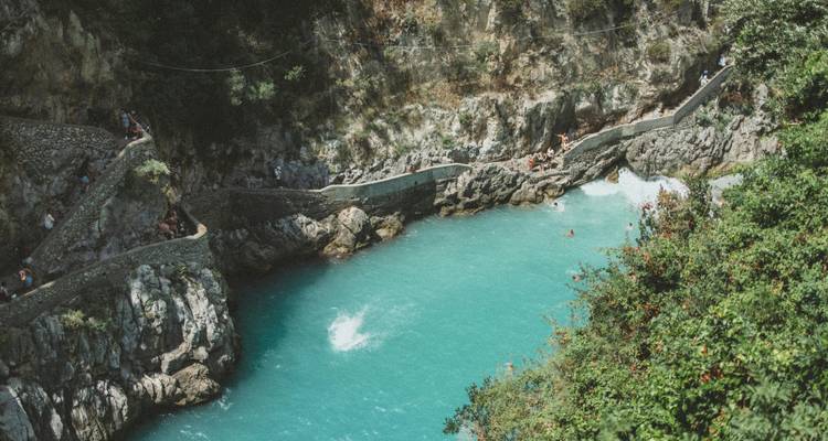 Turquoise zwembad van de Fiordo di Furore omringd door stenen muren en badgasten.