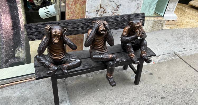 Bronze bench sculpture of three monkeys depicting see-no-evil, hear-no-evil, speak-no-evil