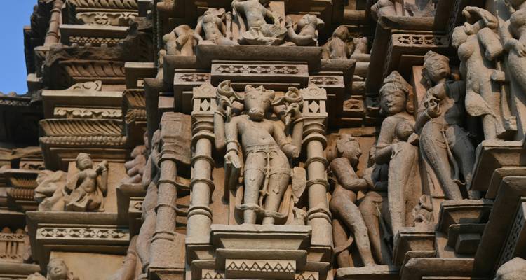Intricate sandstone sculptures and carvings on the walls of a historic Hindu temple.