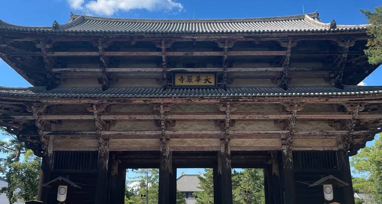 Massive wooden entrance gate of a historic Buddhist temple set against a blue sky.