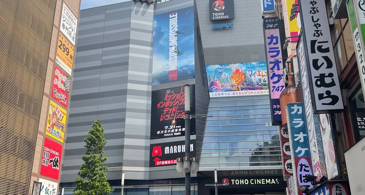 Modern Shinjuku building with large Toho Cinemas facade and colorful vertical signage.