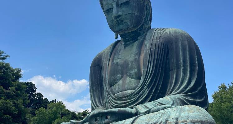 The colossal bronze Great Buddha of Kamakura seated against a bright blue summer sky.