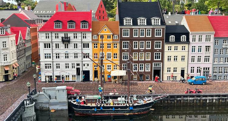 Gedetailleerde LEGO-miniatuur van kleurrijke gebouwen aan het kanaal en bootjes.