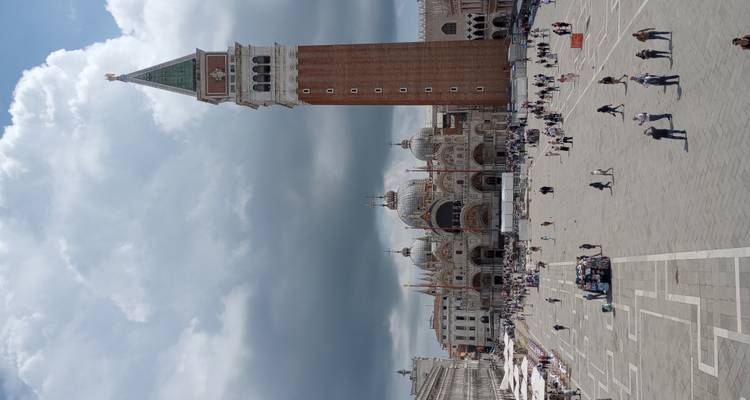 Piazza San Marco mit dem aufragenden roten Campanile aus Backstein und der Basilika unter dramatischen Wolken.