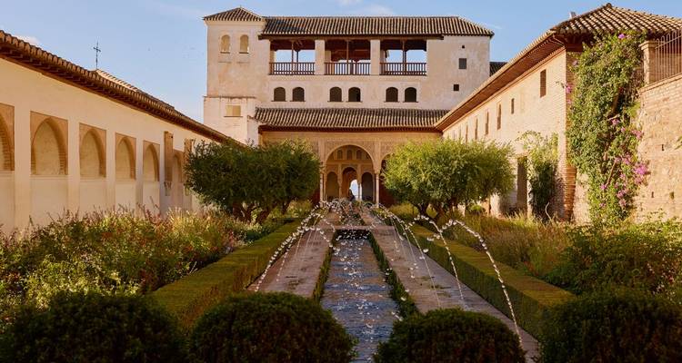 Elegant Moorish courtyard of the Alhambra’s Generalife with hedges and dancing water jets.