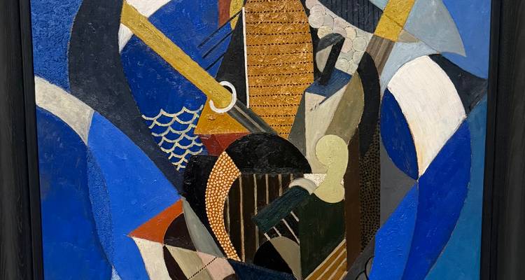 Un tableau abstrait de style cubiste dominé par des bleus et des formes géométriques est exposé dans une galerie.