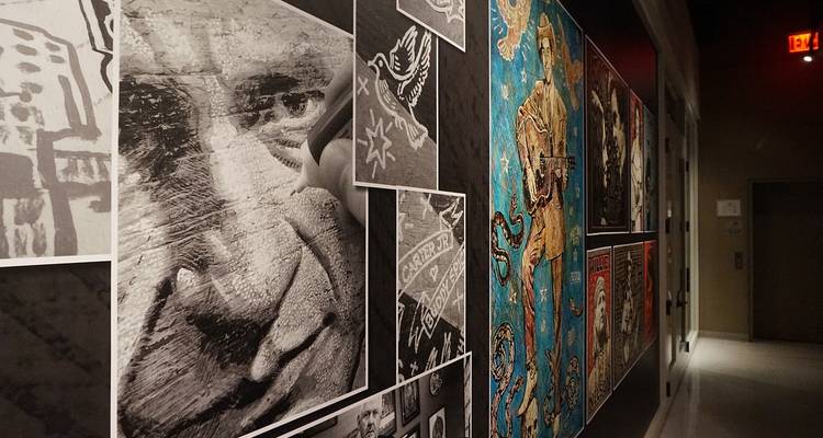 Ausstellungsbereich im Flur mit schwarz-weißen Porträts und farbenfrohen musikthematischen Kunstwerken an den Wänden.