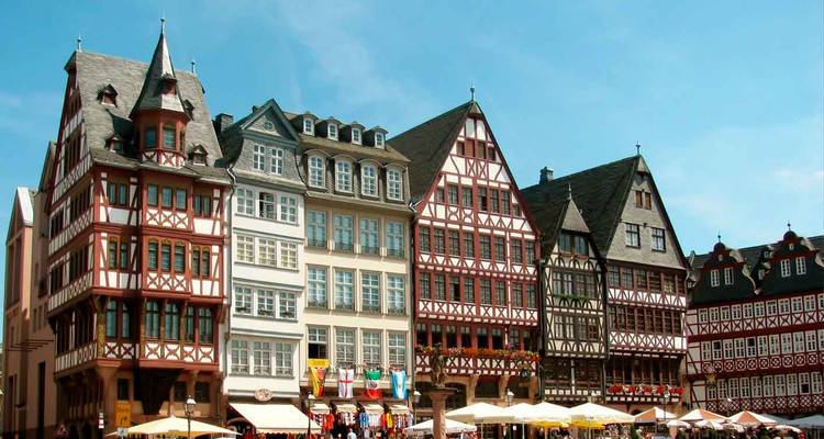Fachadas de entramado de madera de la plaza Römerberg de Frankfurt con cafés al aire libre llenos de vida.