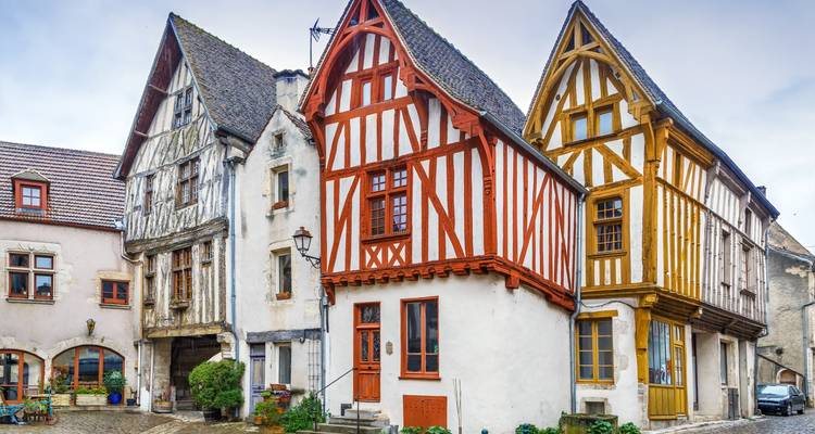 Charmantes maisons à colombages médiévales regroupées sur une rue pavée à Noyers.