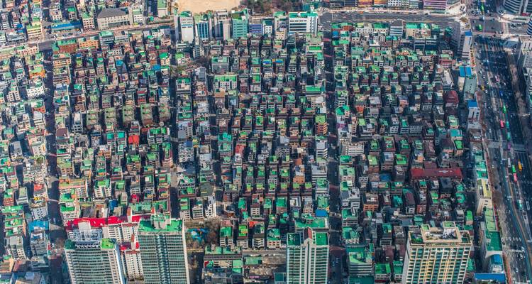 Densely packed urban neighborhood seen from above with rows of green-roofed buildings in Seoul