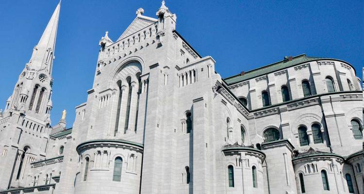 Close-up of ornate grey stone basilica under clear blue sky