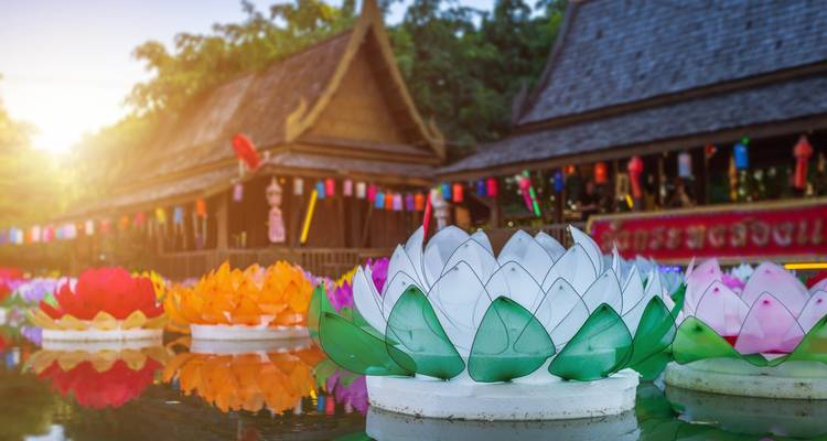 Des lanternes de lotus en papier coloré flottant sur l'eau dans un temple lors d'une fête avec un effet de soleil