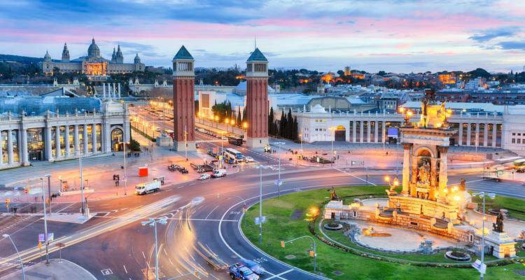 Avondaanzicht over Plaça d'Espanya met Venetiaanse Torens, lichtsporen van verkeer en MNAC in de verte in Barcelona.