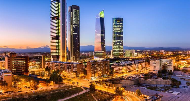 Schemering skyline van Madrid's Cuatro Torres Business Area met stadslichten die net beginnen te gloeien.