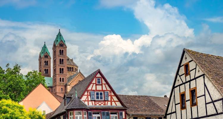 La catedral de dos torres de Speyer se eleva sobre los pintorescos tejadillos de la aldea de entramado de madera bajo nubes esponjosas.