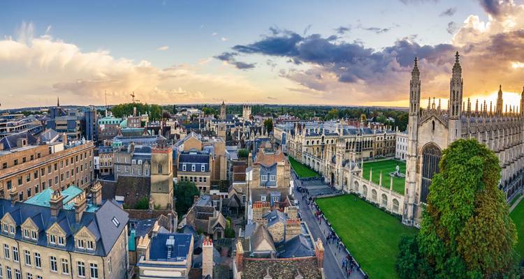 Wide sunset view over Cambridge rooftops with King's College spires on the horizon