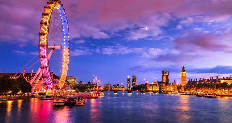 London Eye and illuminated Houses of Parliament reflecting on Thames at vibrant twilight