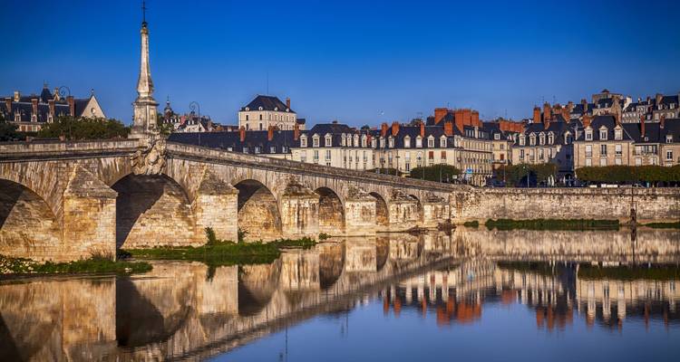 Historische Steinbrücke über die Loire mit eleganten Blois-Fassaden, die sich im ruhigen Wasser spiegeln.