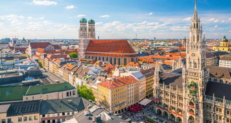Luftaufnahme des Marienplatzes in München mit Frauenkirche und Neuem Rathaus unter blauem Himmel