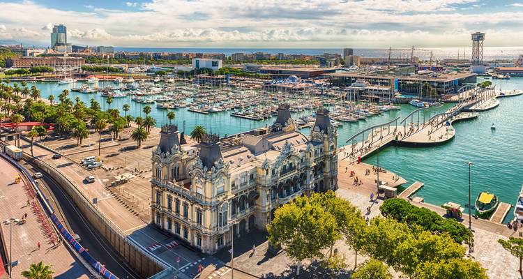 Aerial view over Barcelona’s marina with historic customs building and countless boats.