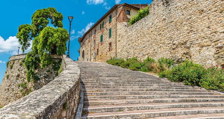 Long escalier en pierre menant aux murs de la forteresse sous un ciel bleu éclatant.