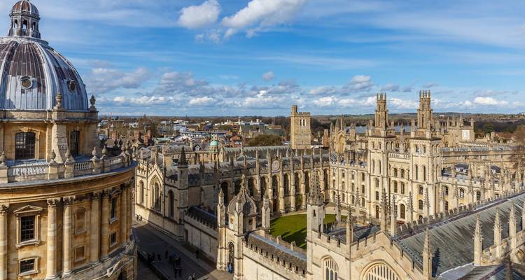 Historic Oxford skyline featuring Radcliffe Camera dome and spires under a bright sky.