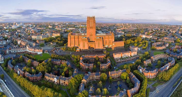 Panorama aérien de Liverpool mettant en évidence la majestueuse cathédrale anglicane entourée par les rues résidentielles de la ville.