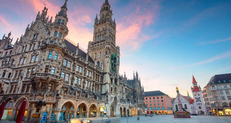 L'Hôtel de Ville du Nouveau Quartier de style néogothique domine la Marienplatz de Munich sous un ciel à l'aurore aux tons pastel.