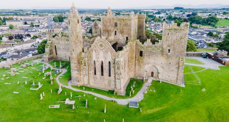Aerial image of the Rock of Cashel ruins dominating a green hill above the surrounding town.