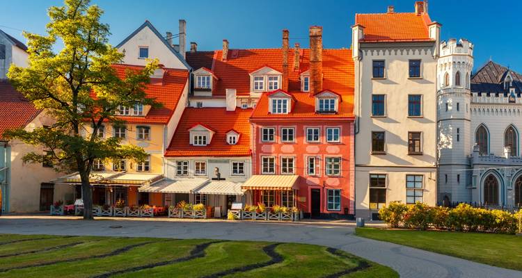 Quaint colorful medieval houses and outdoor cafes under clear blue Riga sky