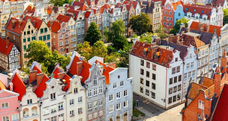 Vista aérea del Casco Antiguo de Gdansk con sus características casas de tejadillos, coloridas y techos rojos entre árboles.