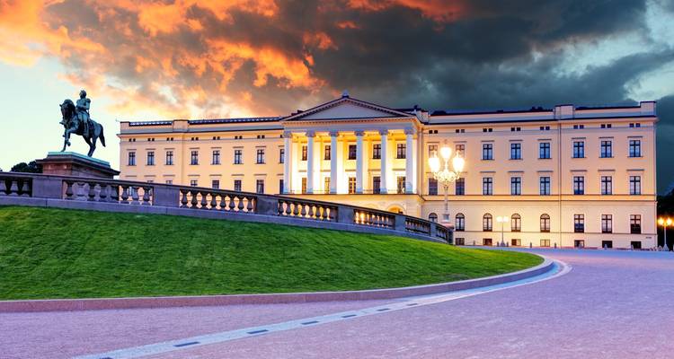 Oslo’s Royal Palace and equestrian statue lit against a dramatic orange-tinged sunset sky.