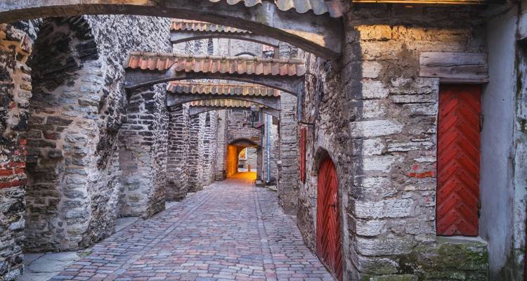 Ruelle médiévale pittoresque pavée de pierres avec poutres cintrées et sol en pavés dans la vieille ville de Tallinn.