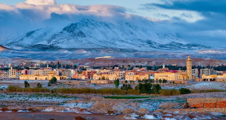 Ville de Midelt au pied d'une montagne aux sommets enneigés, saupoudrée de neige hivernale.