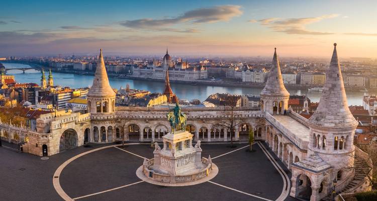 Sunrise view from Fisherman’s Bastion over the Danube toward the Parliament, with soft golden light illuminating the neo-Romanesque towers.