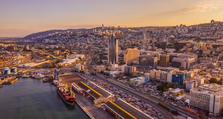 Luchtfoto van zonsondergang boven de haven van Haifa met skyline van de stad die Mount Carmel opklimt.