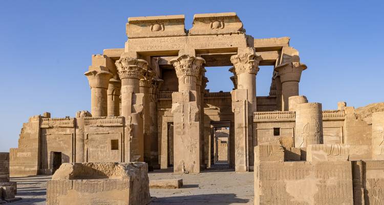 Gut erhaltene Sandsteinsäulen und Reliefs des Tempels von Kom Ombo unter klarem Himmel.