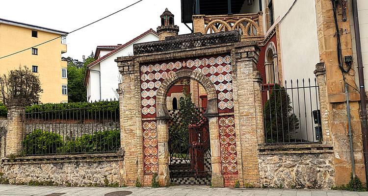 Portail mauresque en brique et carrelage décoratifs donnant sur le jardin d'une villa historique
