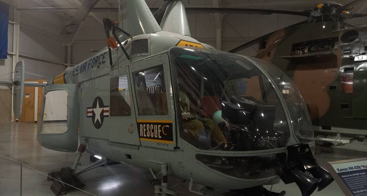 Restored vintage U.S. Air Force rescue helicopter displayed inside an aircraft hangar museum.
