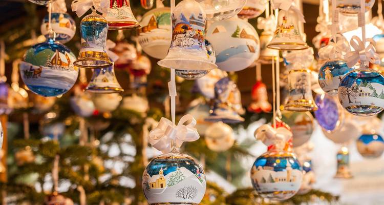 Collection of hand-painted Christmas baubles and bells hanging in a festive display.