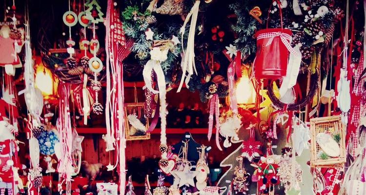 Assortiment dense d'objets artisanaux festifs suspendus, d'ornements et de rubans aux couleurs éclatantes.