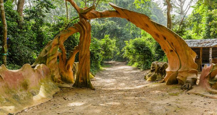 Repeat view of the natural clay arch entrance amid dense Nigerian forest.