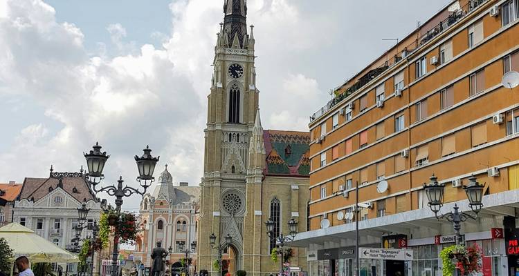 Centraal plein van Novi Sad met de hoge spits van de katholieke Mariakathedraal en omringende gebouwen.