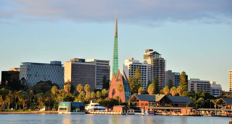Horizonte de Perth con la icónica Torre Swan Bell de cúpula verde vista desde el otro lado del río Swan al atardecer.